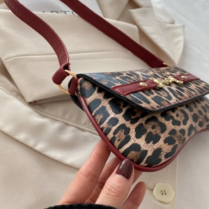 Large leopard print shoulder bag with red leather trim and golden metal hardware