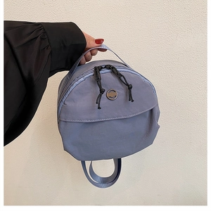 Detailed view of lavender nylon mini round bag with double zipper and top handle
