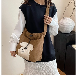 Brown corduroy crossbody bag with cute dog patch shown on female model