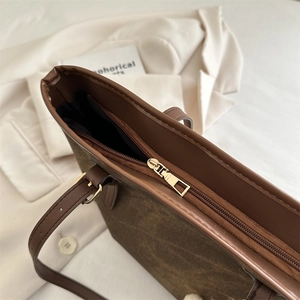 Deep brown matte faux leather tote bag with gold zipper and minimalist design