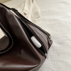 Large dark brown soft leather backpack with hidden side pocket for earphone storage