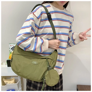 Close-up of olive green nylon crossbody bag with adjustable strap and small round pouch