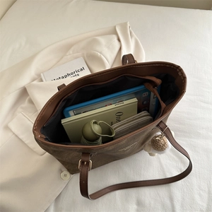 Large brown tote bag with zipper showing internal space for tablets and wallets