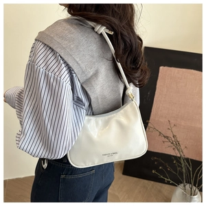 Detail of white leather hobo bag with Fashion & Bags Leather text on striped outfit