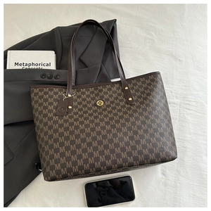 Detail of monogram pattern and gold M logo on brown leather shoulder tote bag