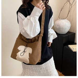 Brown corduroy shoulder bag with white puppy embroidery patch and side pockets