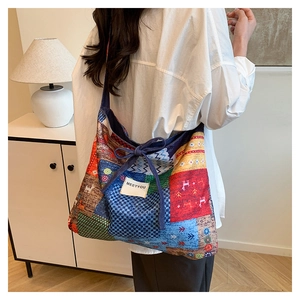 Detail of ethnic denim patchwork tote with colorful patterns and bow shoulder strap knot