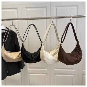 Detail showing four solid color half-moon bags in pebble leather with gold branding