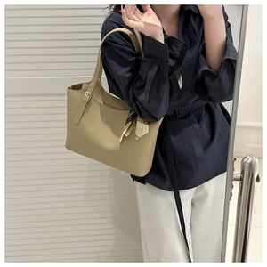 Detail of beige soft leather tote bag with printed silk scarf charm and metal buckle
