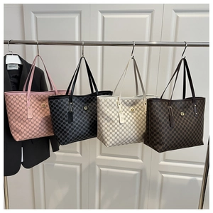 Close-up of four luxury tote bags with 'M' monogram print and metallic logo charms
