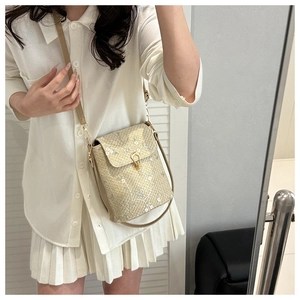 Detailed embroidery on woven straw bucket bag with delicate flowers and leather strap