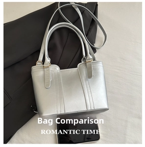 Detail of silver tote bag with metallic finish showing smartphone for size comparison