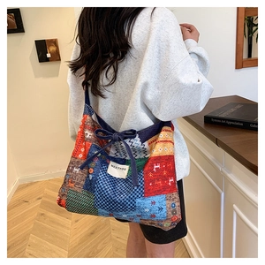 Detailed back view of a large patchwork canvas tote bag with floral patterns and bow