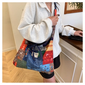 Detailed shot of ethnic patchwork tote bag featuring reindeer pattern and brand label