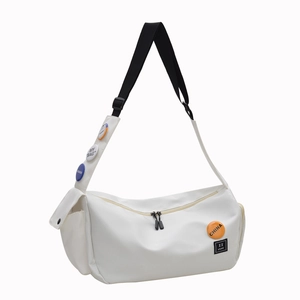 White nylon messenger bag with adjustable black strap and colorful decorative badges