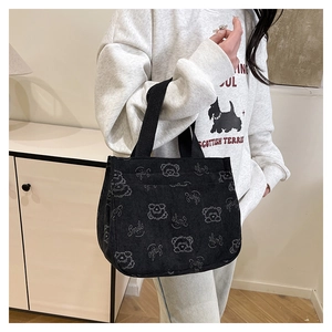 Dettaglio borsa tote in velluto a coste nero con motivo orsetto e scritta smile