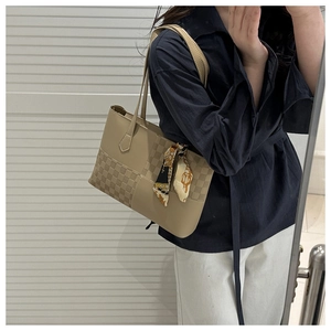 Detail of khaki tote bag featuring classic plaid pattern and decorative floral silk scarf