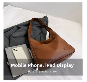 Brown bucket shoulder bag showing storage capacity for tablets and mobile phones