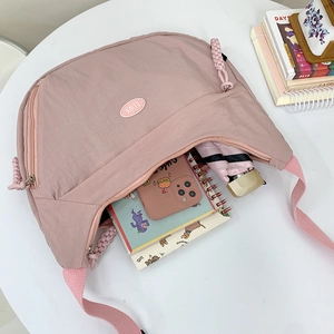 Pink nylon crescent crossbody bag for women showing large capacity interior storage
