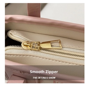 Detail showing high-quality gold metal zipper on minimalist pink leather tote bag