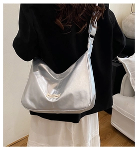 Détail du sac hobo argenté métallisé avec étiquette Fashion Bag sur un blazer noir