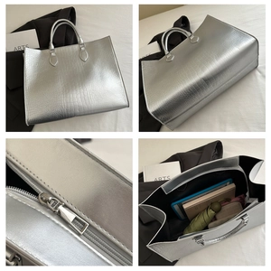 Detail view of silver tote bag showing crocodile texture, zipper and spacious interior