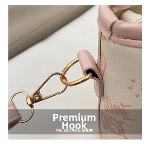 Close-up of premium gold-toned metal hook attachment on beige and pink bucket bag