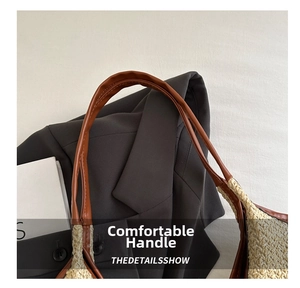 Close-up of brown leather handle and woven straw texture on large beach tote bag