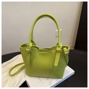 Detail of neon green tote bag showing vertical stitching and detachable shoulder strap