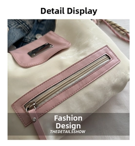 Detail view of the two-tone tote bag showing pink zipper pocket and metallic logo plaque
