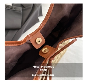 Detailed close-up of premium light gold magnetic snap closure on a brown woven tote bag