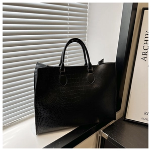 Detailed view of large black tote bag with premium crocodile embossed leather texture