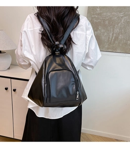 Detail view of water-drop shaped black PU leather backpack with sleek front zipper pocket