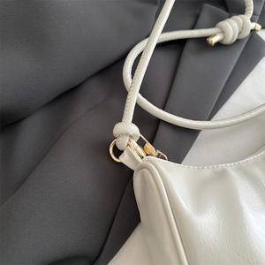 Silver glossy baguette shoulder bag for women with elegant gold hardware and knot detail