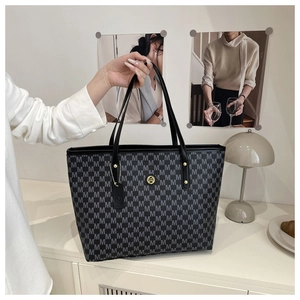 Detail shot of monogram pattern and circular metal M logo on the large tote bag