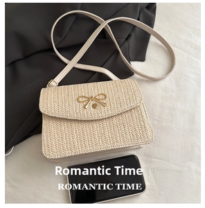 Detail of woven crossbody bag featuring a golden bow metal buckle on beige straw texture