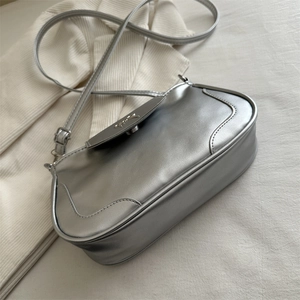 Silver metallic crossbody bag with stylish bow hardware and adjustable shoulder strap