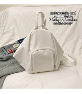 Detailed view of a white geometric minimalist backpack with PU leather texture and front pocket