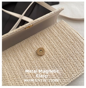 Detail of light gold magnetic snap closure on a beige woven herringbone crossbody bag