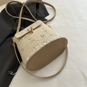Straw bucket bag with floral embroidery and adjustable leather strap for summer