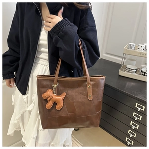 Détail du sac cabas en cuir patchwork marron avec un joli bijou de sac en forme de chien