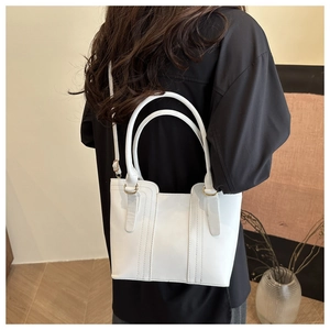 Gros plan d'un sac à main blanc élégant porté en bandoulière avec des détails dorés