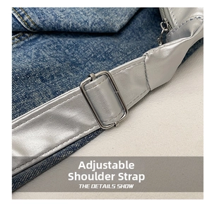 Détail de la bandoulière argentée réglable avec boucle en métal sur un sac en denim