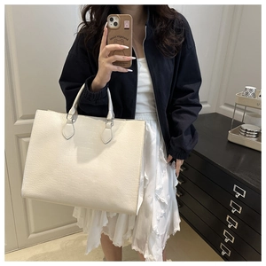 Mirror selfie showing the large cream white crocodile embossed tote bag with casual outfit