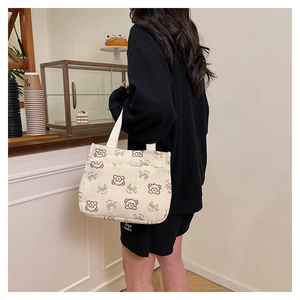 Borsa tote in velluto a coste con orsetto e stampa Smile in un ambiente di caffè