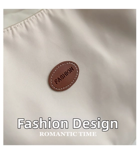 Detail of waterproof nylon tote with fashion leather patch and contrast stitching