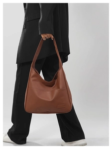 Brown soft leather tote bag detail showing large capacity and side view on a model