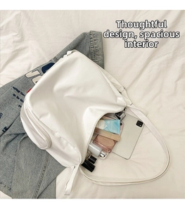 Top-down view of a spacious white PU leather tote bag containing a tablet and cosmetics