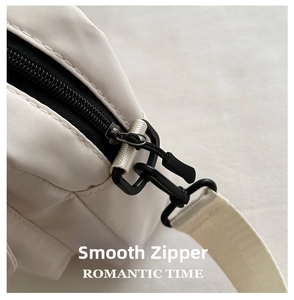 Detail of smooth black zipper and durable metal hook on nylon crossbody bag