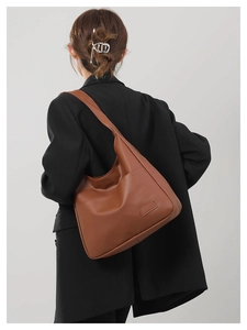Caramel brown large hobo tote bag in premium PU leather shown on shoulder with black blazer